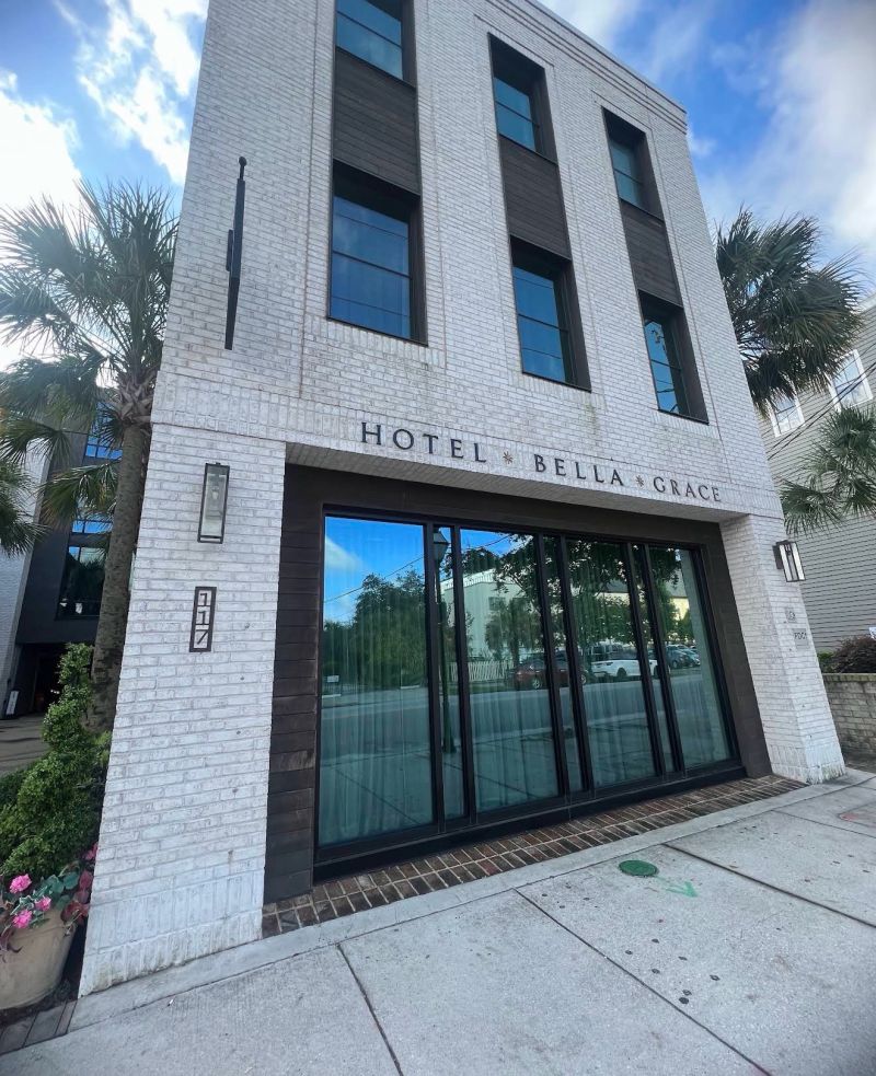 Exterior of the white brick Hotel Bella Grace building on Calhoun Street in Charleston, South Carolina